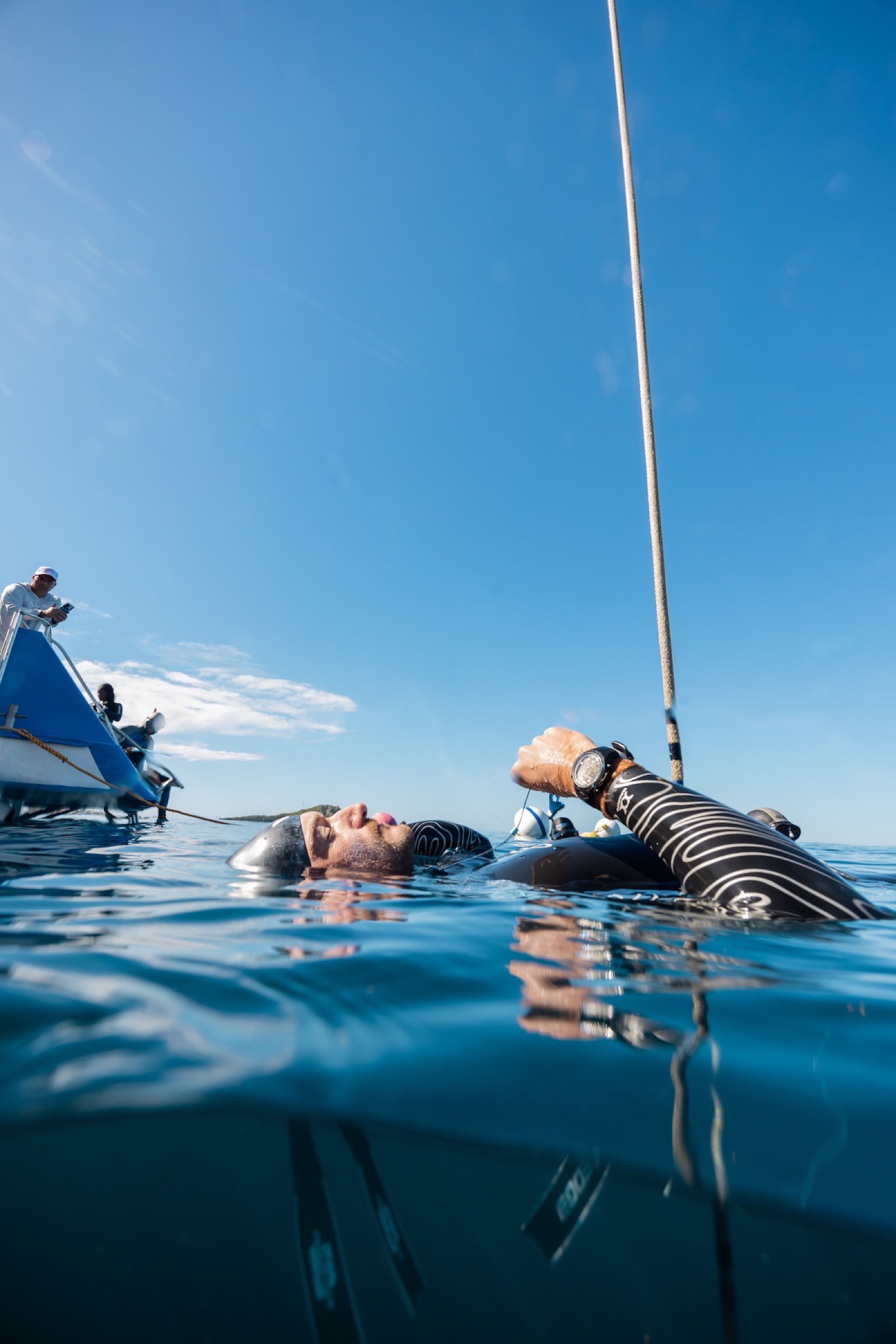 A freediver relaxing at the surface during the breathe-up before a dive