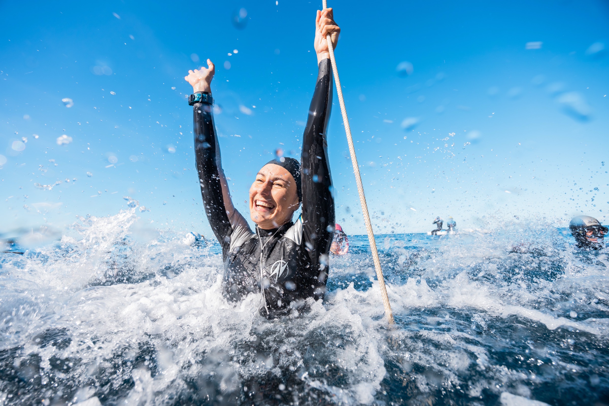 An athlete celebrating at the surface after a clean dive