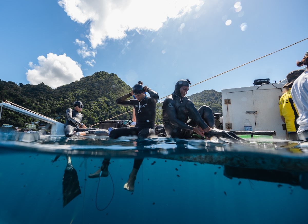 Freedivers preparing on the platform in the clear water of Soufrière Bay