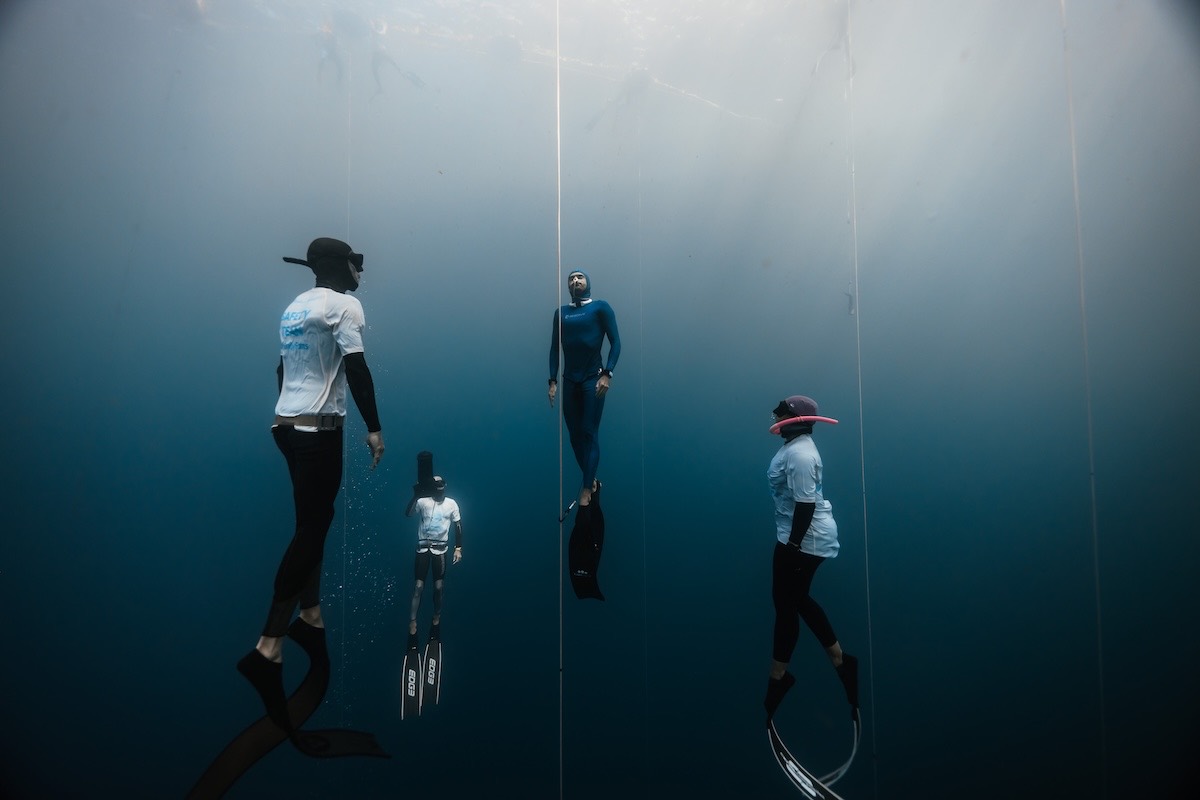 Safety divers meeting a competitor deep on the line
