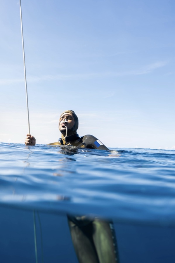 A freediver breathing up at the surface before a dive