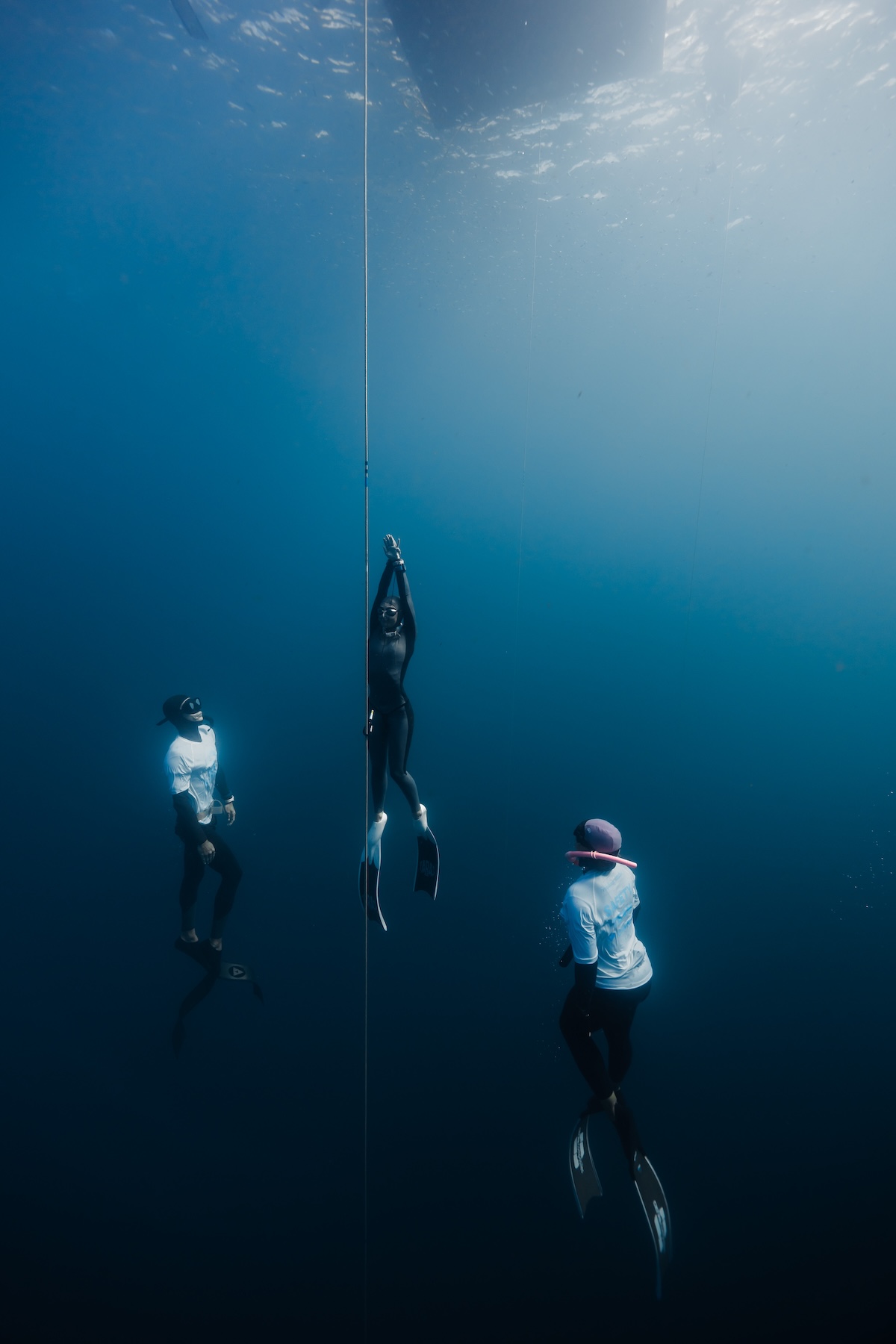 Diver on the line flanked by two safety divers